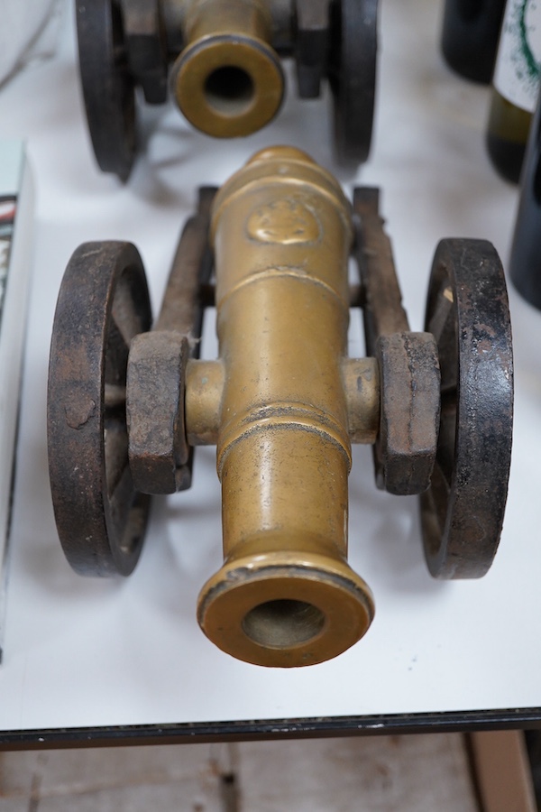 A pair of brass and cast iron model cannons, 34cm in length